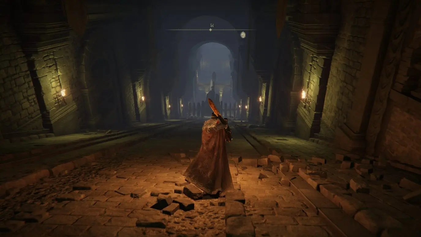 A warrior looks down a large sloped chamber in Auriza Hero&rsquo;s Grave in Elden Ring.