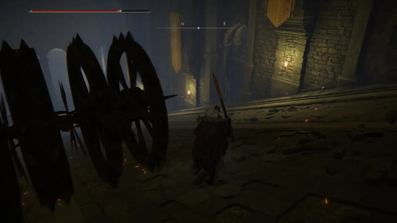 A warrior dodges two large chariots in Auriza Hero&rsquo;s Grave in Elden Ring