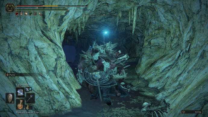 A wad of slime engulfs a Tarnished traversing a cave corridor in Elden Ring: Shadow of the Erdtree.