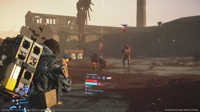 Death Stranding 2 screenshot showing Sam aiming a gun at strange red mech enemies outside an industrial facility