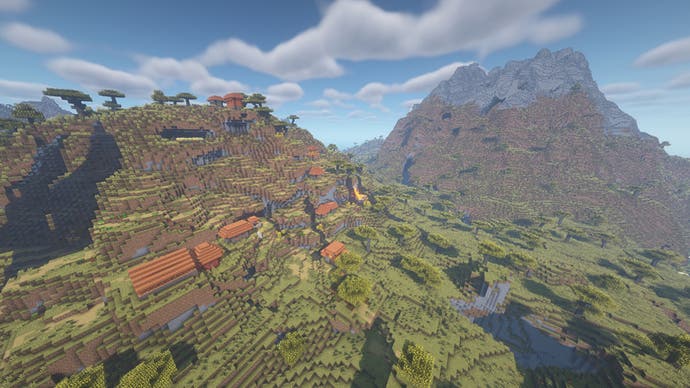 Ein Minecraft-Dorf, das an den Rand eines Savannenhügels gebaut wurde, mit einem großen Berg aus Stein im Hintergrund.