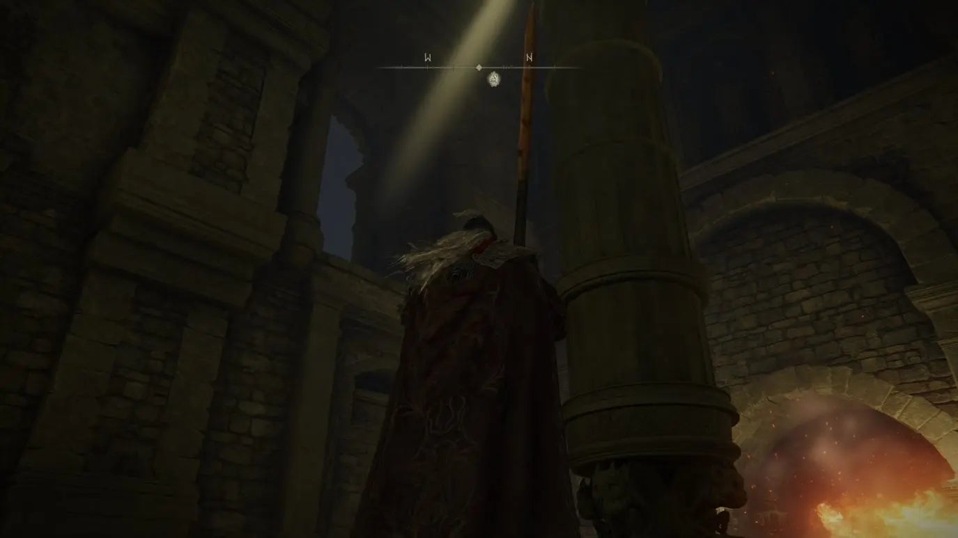 A warrior looks up at a beam of light in Auriza Hero&rsquo;s Grave in Elden Ring.