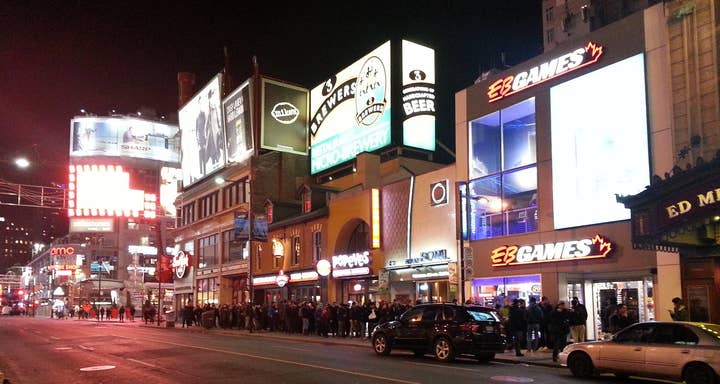 A late night picture of Yonge St. in Toronto for the PS4 launch. There is an EB Games store with a line of more than 100 people stretching down the street
