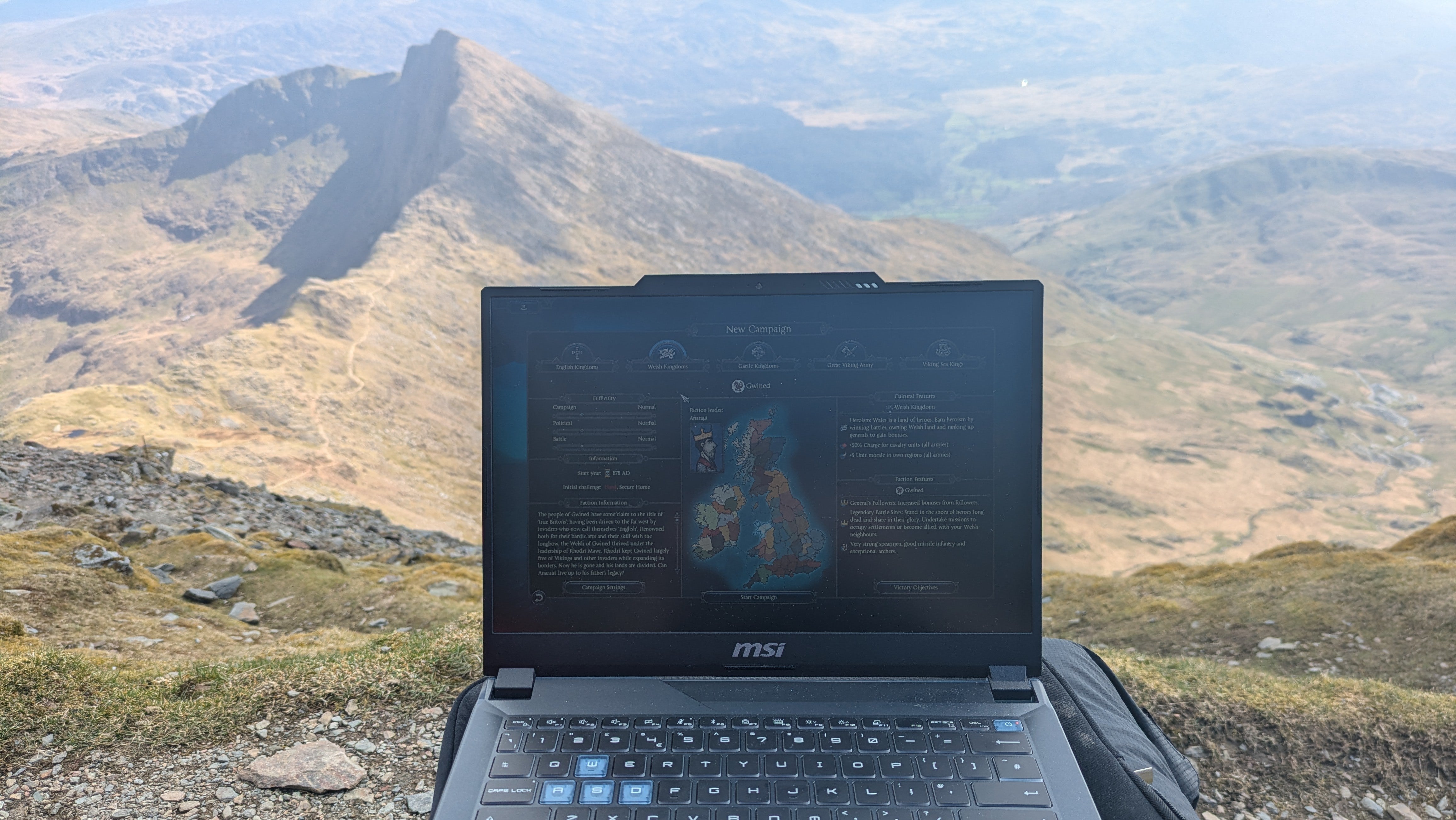 A view of an MSI Cyborg 14 laptop playing a Total War game with mountains visible behind.
