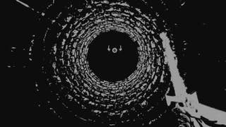 A view from the bottom (or is it the top?) of a stone well, with a hand holding a white burning sword on the right, rendered in murky black and white visuals. From the video game Nix Umbra.