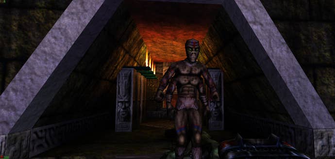 A screenshot of an NPC standing in a triangular hallway in Epic’s 1998 shooter Unreal.