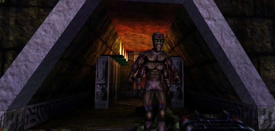 A screenshot of an NPC standing in a triangular hallway in Epic's 1998 shooter Unreal.