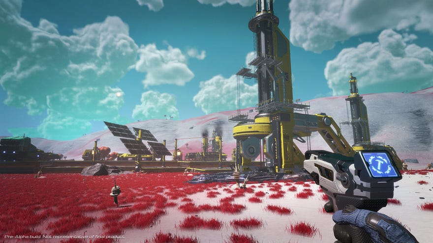 A scene of a red and white planet surface with tall yellow metal structures and the player’s hand holding a weapon in the foreground.