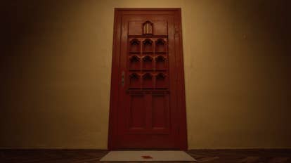 A sinister reddish doorway with smaller portals carved into it, and a golden foil miniature treble doorway astatine the top. There is simply a reddish greetings paper connected the mat beneath.