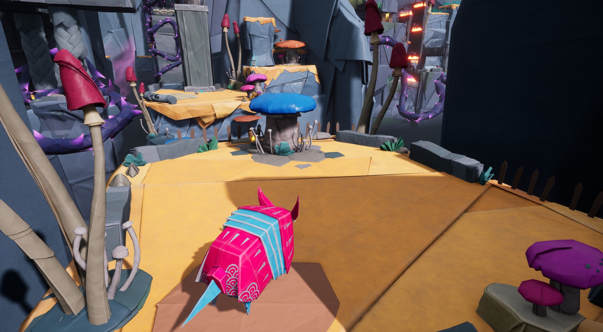 An origami armadillo in red and blue paper on a piece of yellow ground in a rocky area in Hirogami - 1