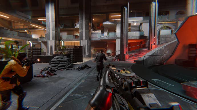 A first-person view of players running with guns through a concrete facility in Den Of Wolves