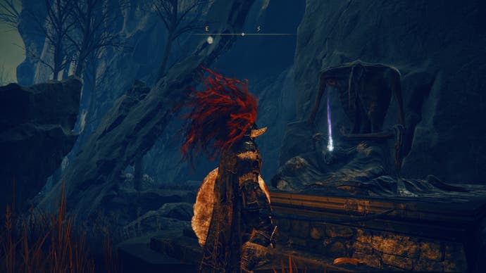 A warrior approaches a Revered Spirit Ash statue in the Village of Flies in Elden Ring Shadow of the Erdtree.