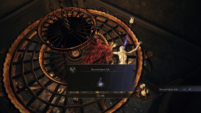 A warrior picks up a Revered Spirit Ash from a corpse on a chandelier in Midra's Manse in Elden Ring Shadow of the Erdtree.