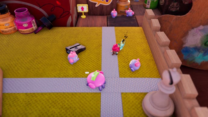 Plucky Squire memerangi bug kartun di atas desktop anak-anak. Sepotong catur berdiri di dekatnya serta beberapa botol cat.