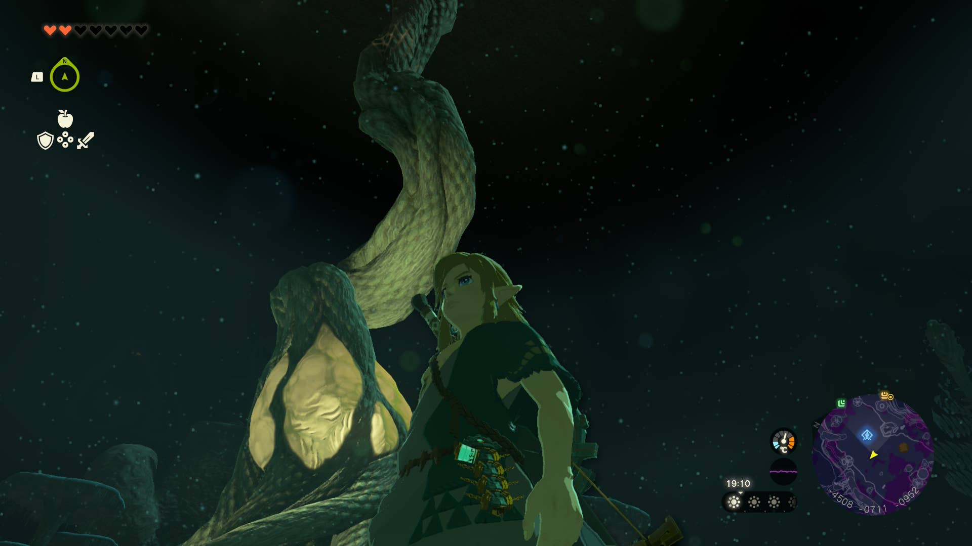 Link in the depths next to a glowing root in Tears of the Kingdom.