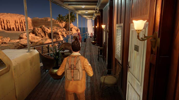 Screenshot from Agatha Christie’s Death on the Nile of Hercule Poirot walking along the deck of a boat wearing a jaunty little European knapsack