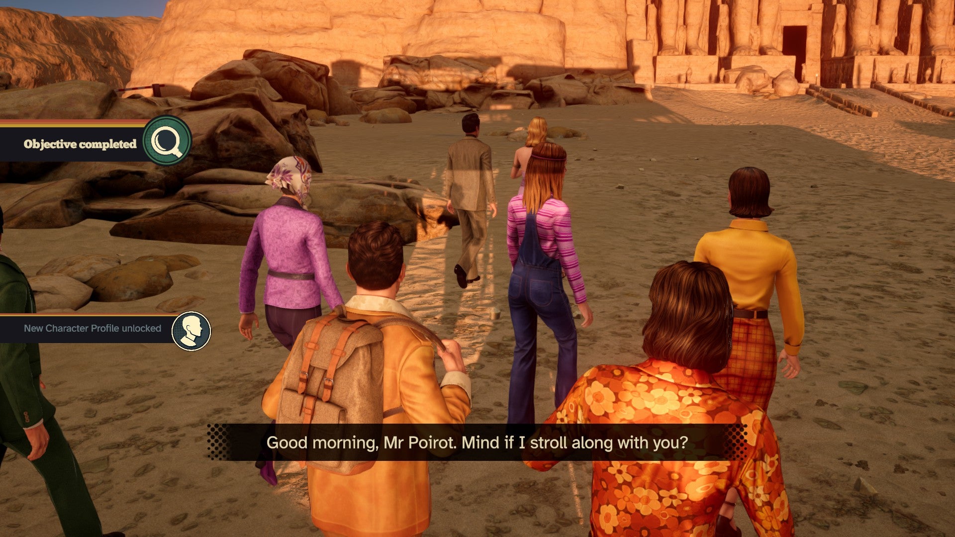 Screenshot from Agatha Christie&rsquo;s Death on the Nile of Hercule Poirot and the rest of the Karnak&rsquo;s passengers walking toward the Temple of Abu Simbel while one of them says &ldquo;Good morning, Mr. Poirot. Mind if I stroll along with you?&rdquo;