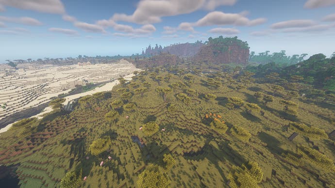 Eine Minecraft-Landschaft mit Wüste auf der linken Seite, Wald auf der rechten Seite und Bergen in der Ferne.