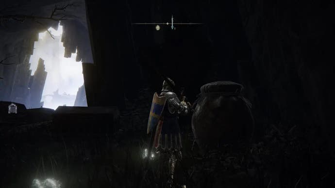 A warrior stands next to a prominent pot in the Albinauric village of Elden Ring.