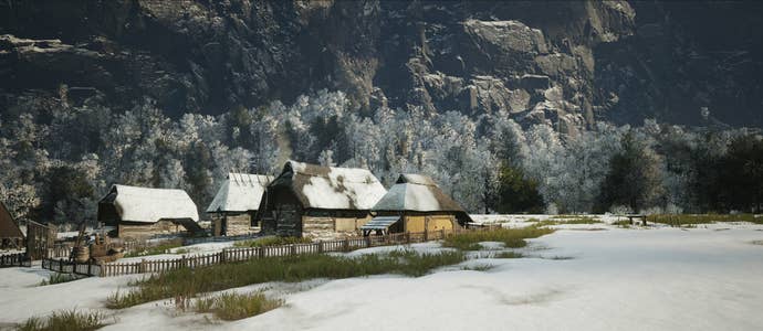 A village in Manor Lords with forest and mountains behind
