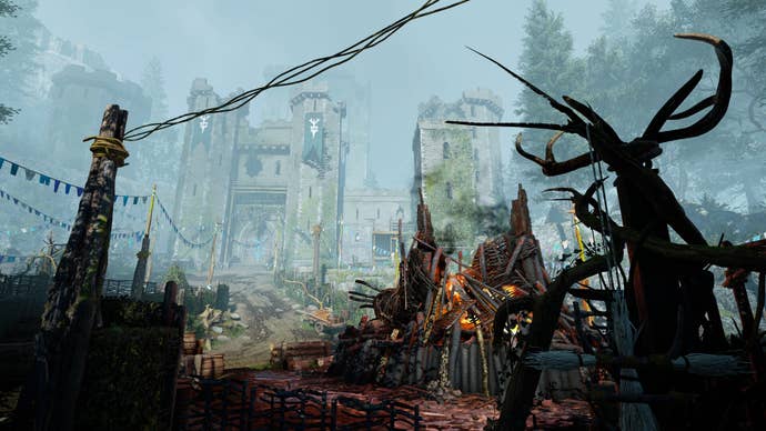 A view of a ruined castle through a bunting-strewn pagan camp in Atomfall