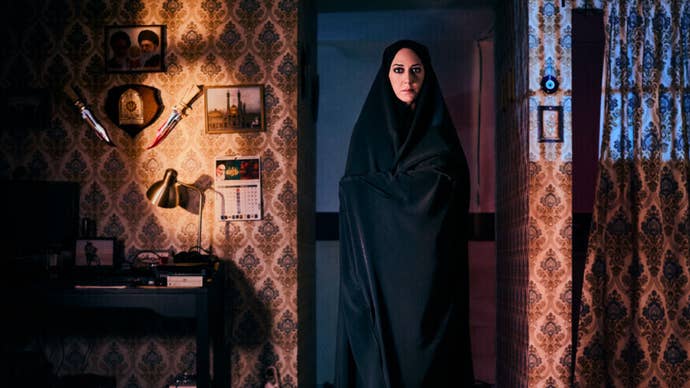 Lili image, showing Iranian woman in hijab standing in doorway next to patterned wallpaper