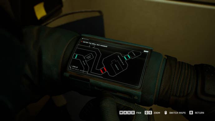 A close-up of the player’s wrist-mounted computer in Fort Solis, showing the wireframe 2D map screen.