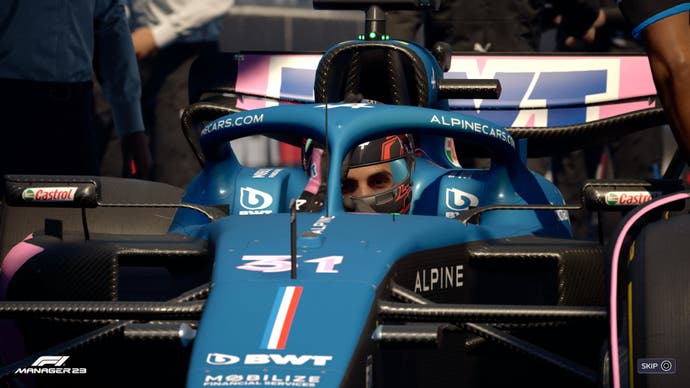F1 Manager 2023 review screenshot, Esteban Ocon in his Alpine car with mechanics nearby.