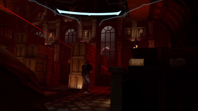 A screenshot showing Batman's POV as he crouches behind a crate, trying to avoid patrolling guards and the red laser from a sniper rifle.