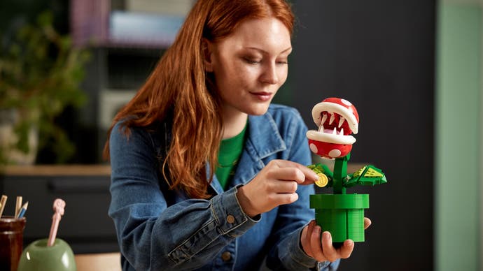 A woman holds Lego's Super Mario Piranha Plant set in her hand.