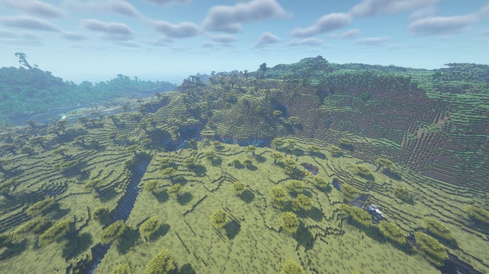 Eine kleine Gebirgskette in Minecraft, mit einer Schlucht im Vordergrund.