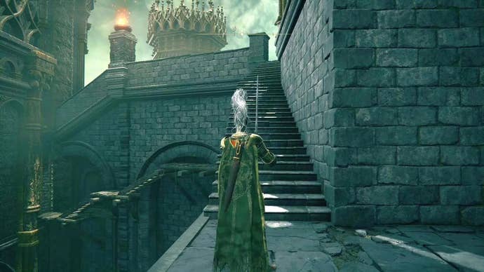 A knight prepares to go up some outdoor steps in Stormveil Castle in Elden Ring.