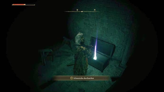 A knight opens a treasure chest in a dark room inside Stormveil Castle in Elden Ring.