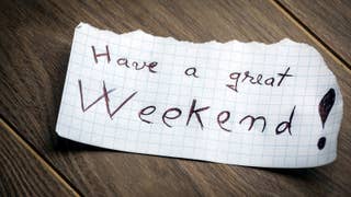 A photograph of a piece of paper that has "have a great weekend" written on it in pen.