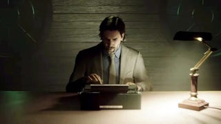 Alan Wake sits at a desk typing in Alan Wake 2