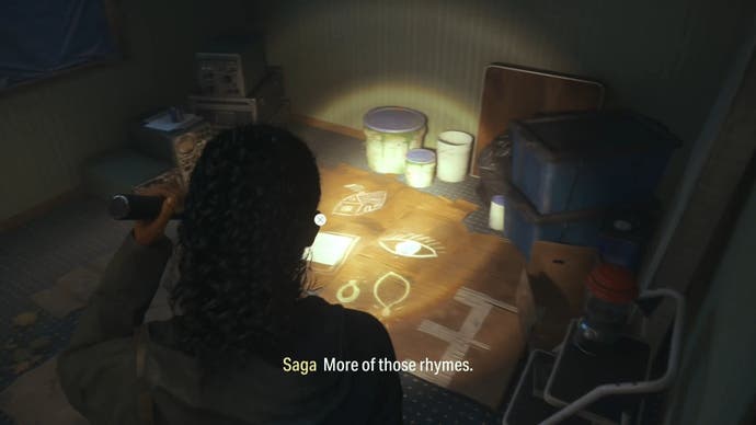 saga shining her flashlight on a nursery rhyme puzzle in a small room inside a trailer