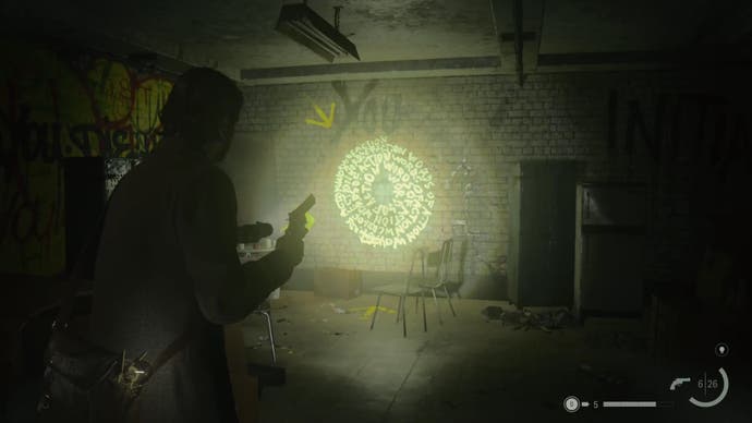 alan shining his flashlight on a word of power on a wall in an abandoned subway station