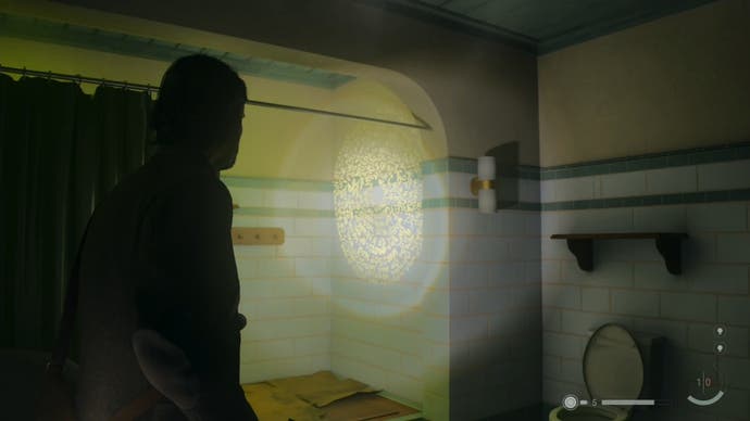alan shining his flashlight on a word of power on the wall of a tiled bathroom