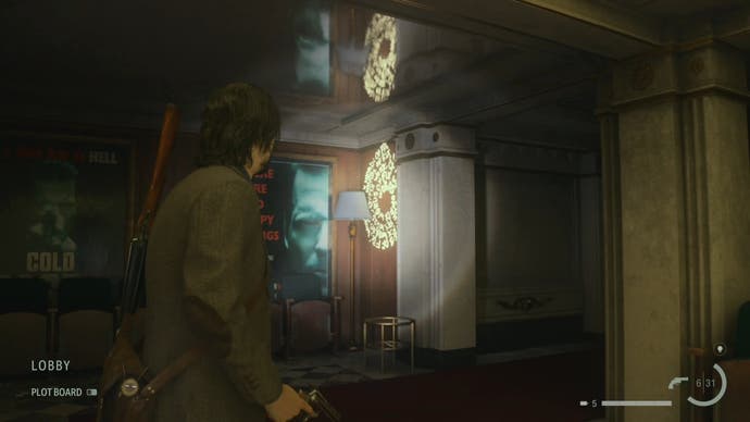 alan shining his flashlight on a word of power on the wall of a cinema with an alex casey poster to the left