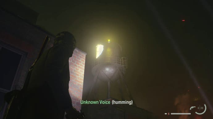 alan shining his flashlight on a word of power on a water tower on a rooftop