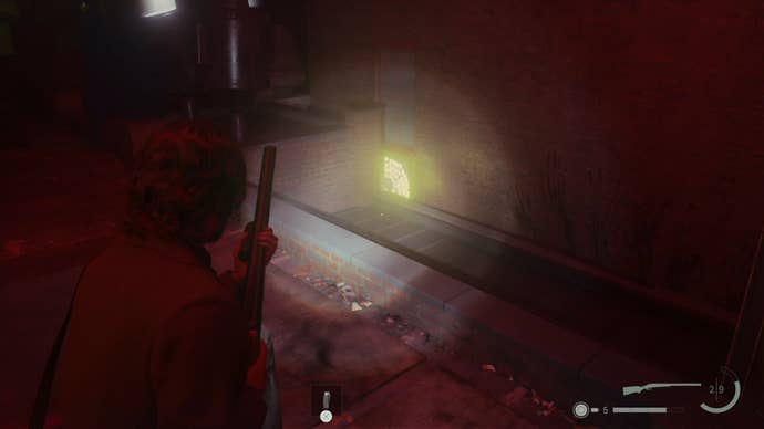 alan shining his flashlight on a word of power on wall across the way from him on a rooftop