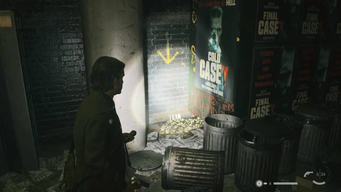 alan shining his flashlight on a word of power on the corner of a messy street with a yellow arrow pointing down to the word