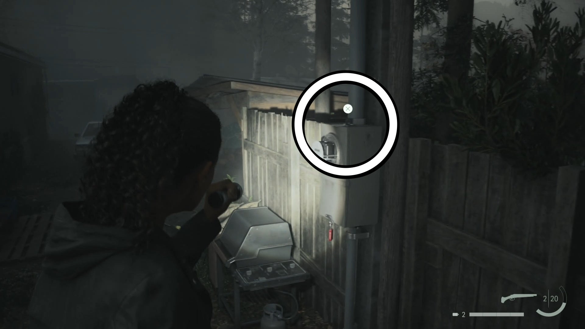 saga shining her flashlight on a cult stash key on top of a box on a white pole in a trailer park