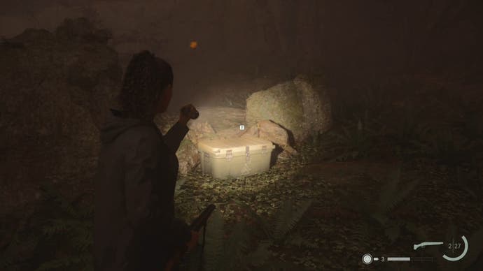 saga shining her flashlight on a cult stash beside a large stone in the woods