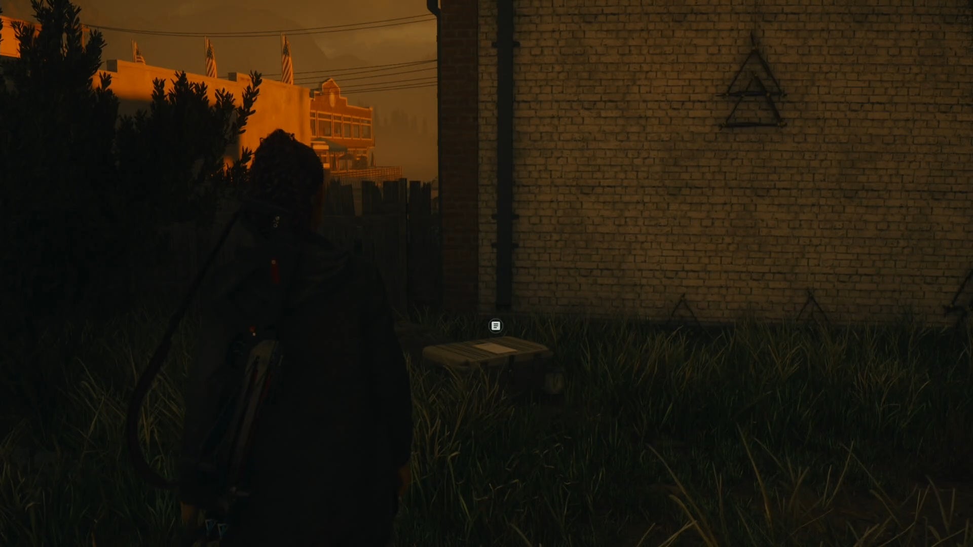 saga looking at a cult stash inside a small yard with a wooden triangle symbol hanging up and to the right