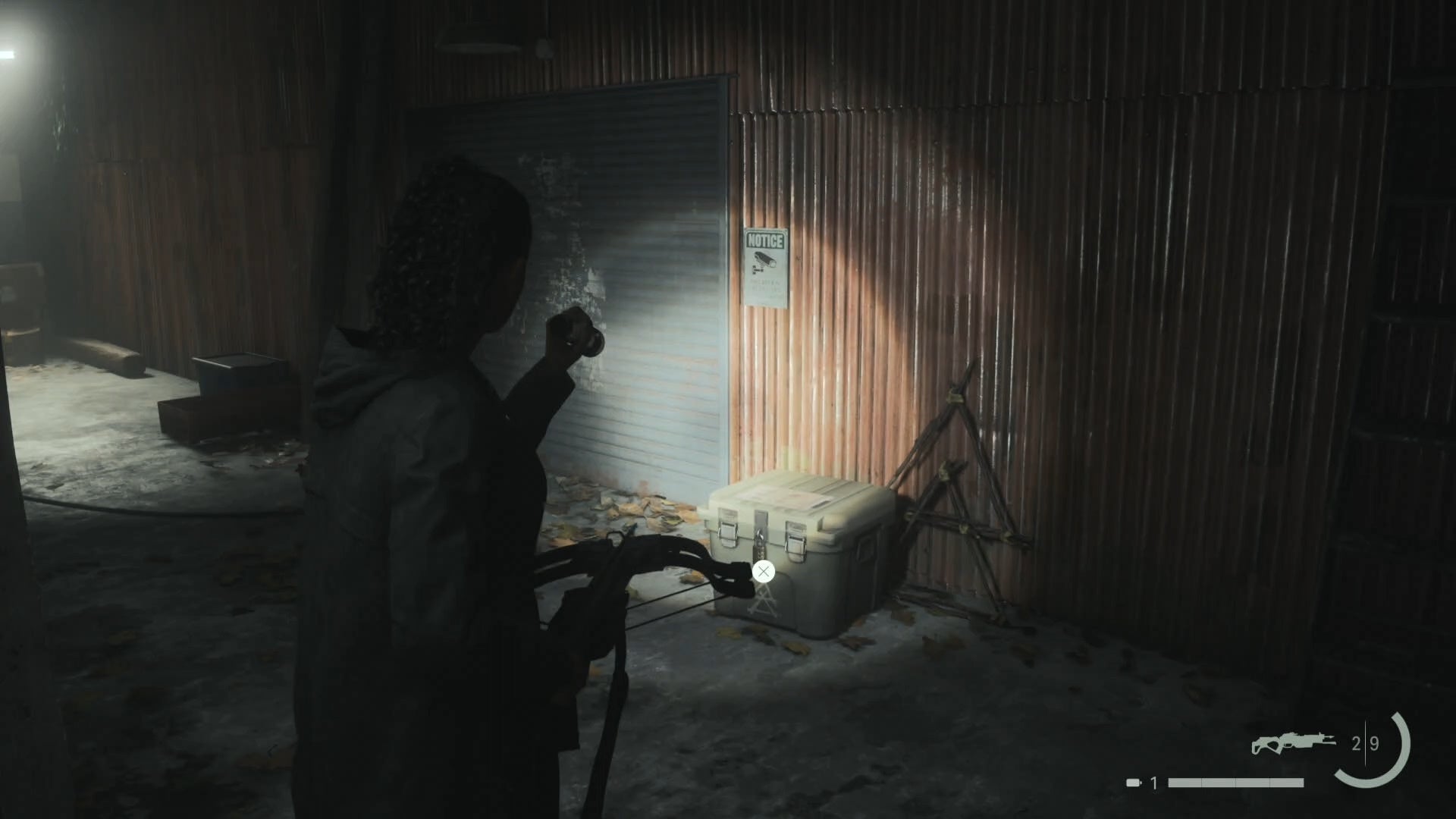 saga shining her flashlight on a cult stash outside a workshop