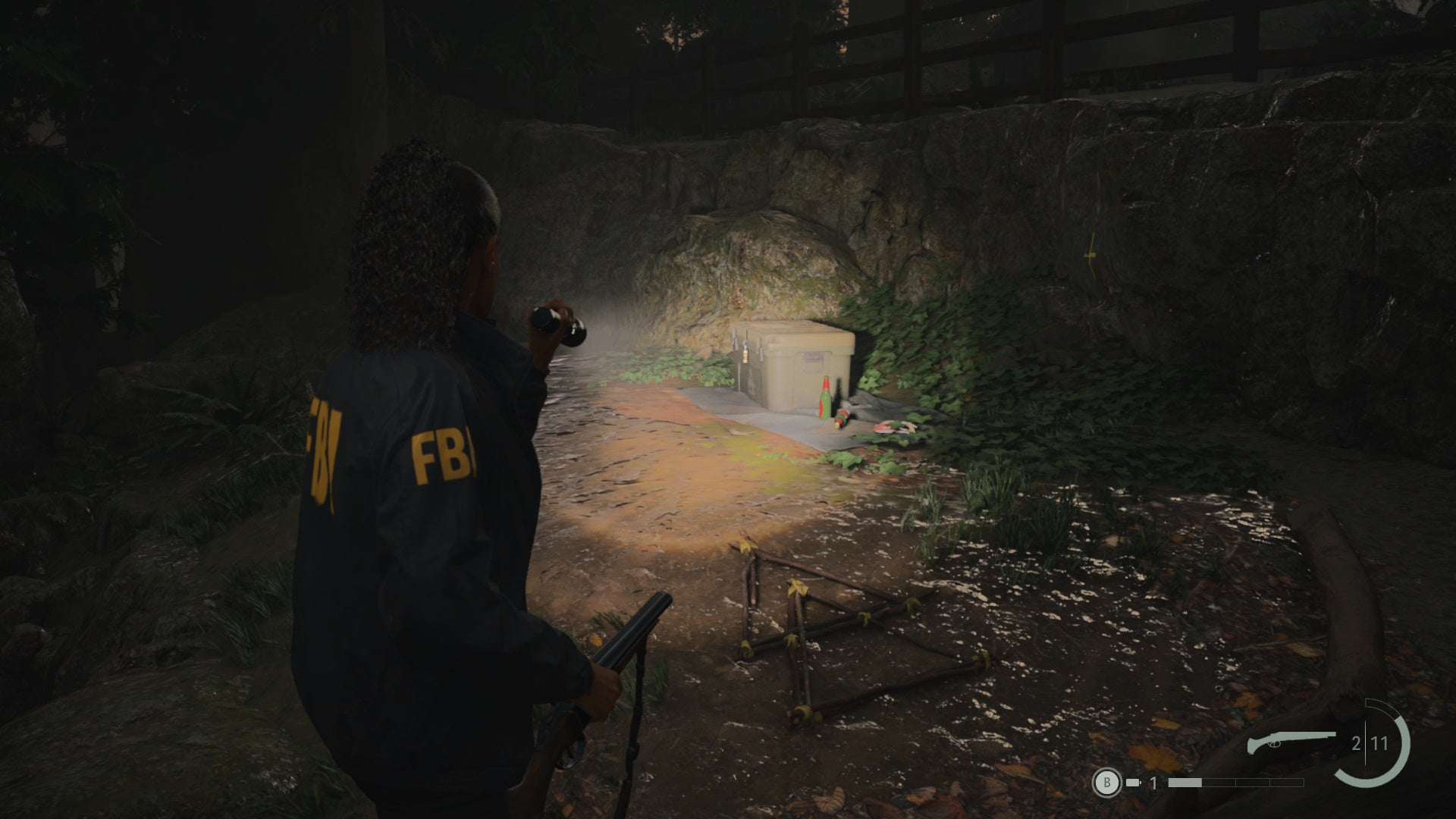 saga shining her flashlight on a cult stash on a muddy path in the woods