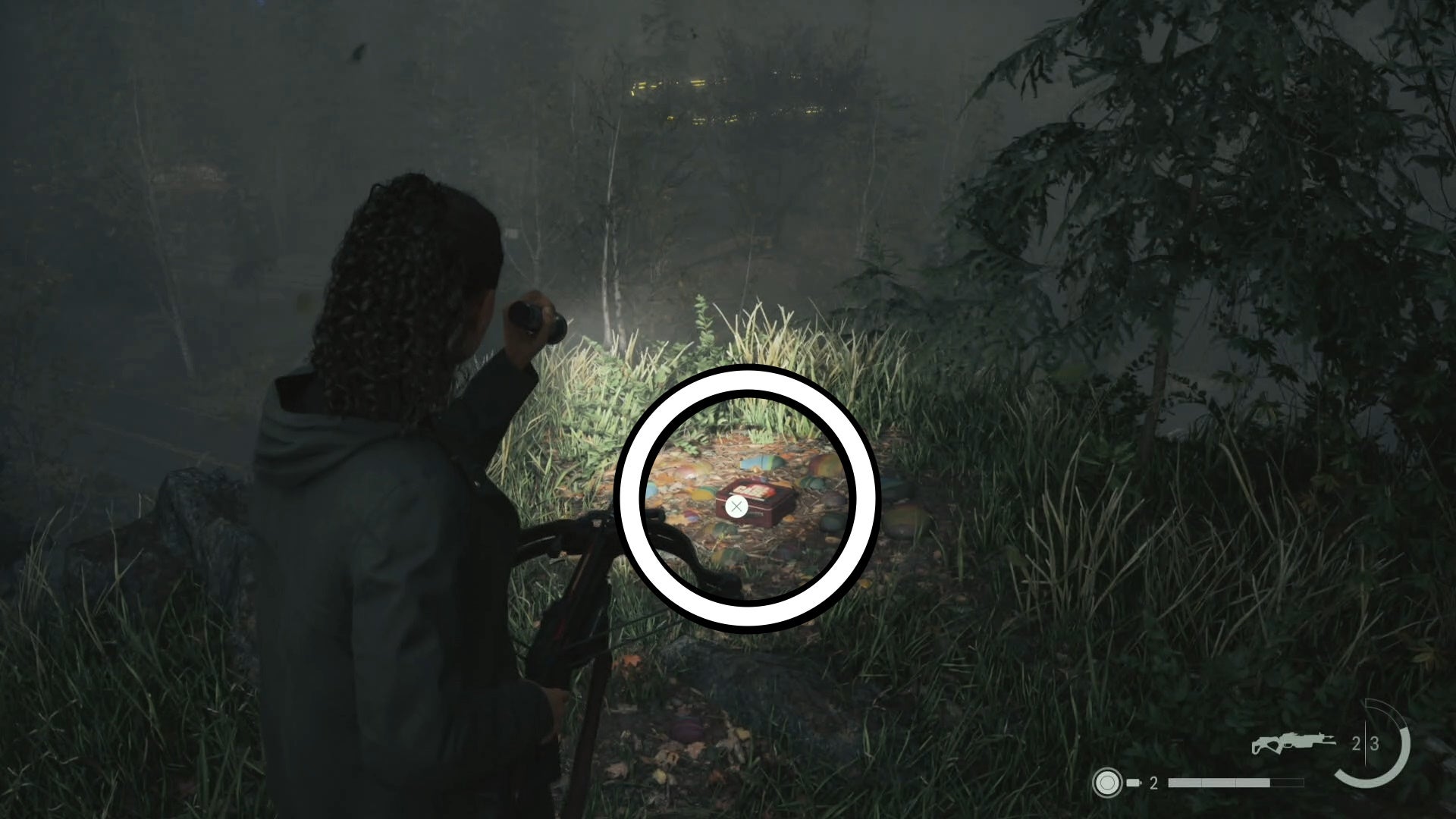 saga shining her flashlight on a lunch box by a clifff in a forest