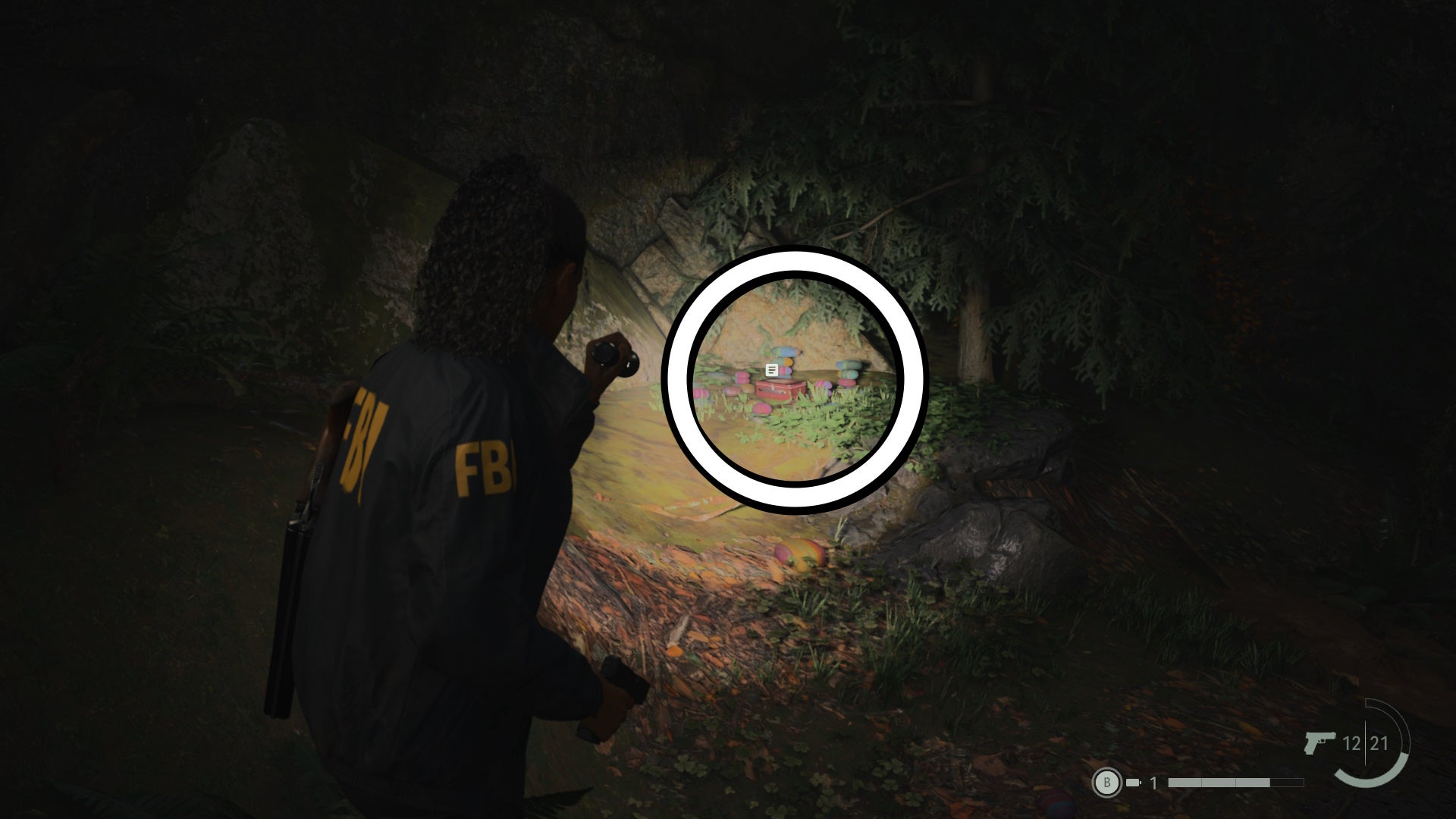 saga shining her flashlight on a lunch box on a forest floor