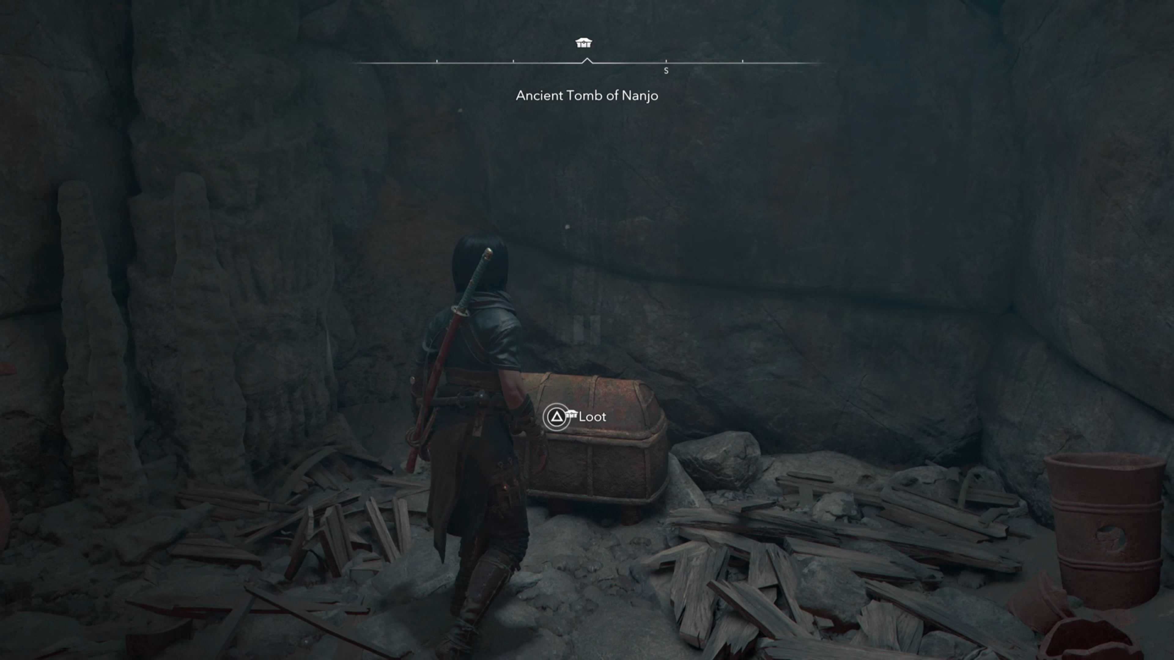 Naoe looking at a chest in a cave in Assassin&rsquo;s Creed Shadows.